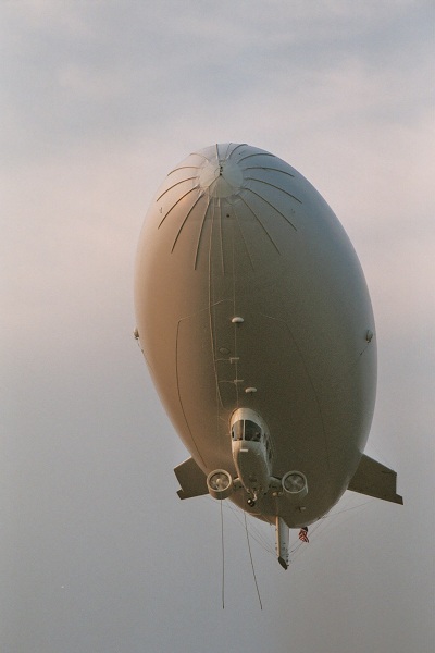  A modern blimp from Airship Management Services showing a strengthened nose, ducted fans attached to the gondola under the hull, and cable-braced fins at the tail. 
